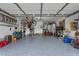 Spacious garage featuring speckled floor coating with ample storage space and a bike suspended from the ceiling at 9324 Carolview Way, Orlando, FL 32836