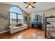 Bright living room featuring hardwood floors, large arched window, and cozy seating area with piano at 9324 Carolview Way, Orlando, FL 32836