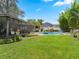 Expansive backyard with a private pool, screened-in patio, lush landscaping, and ample space for outdoor enjoyment at 9543 Buxton, Orlando, FL 32817
