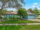 Charming single-story home featuring lush landscaping and a two-car garage at 9543 Buxton, Orlando, FL 32817