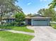 Charming single-story home with lush landscaping, a well-manicured lawn and an attached two car garage at 9543 Buxton, Orlando, FL 32817