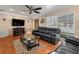 Well-lit living room featuring a ceiling fan, hardwood floors, a decorative fireplace, and generous natural light at 9543 Buxton, Orlando, FL 32817