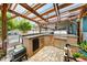 Inviting outdoor kitchen with brick and stone elements, complete with a built-in grill, mini fridge, and a cozy dining space at 9543 Buxton, Orlando, FL 32817
