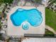 Aerial view of a uniquely shaped private pool with an integrated spa, surrounded by a concrete patio and lush landscaping at 9543 Buxton, Orlando, FL 32817