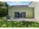 Backyard featuring a patio area accessible through sliding glass doors from the green house at 1065 Universal Rest Pl, Kissimmee, FL 34744