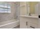Bright bathroom with white marble tile surround, shower and bath combination, and a white vanity at 1065 Universal Rest Pl, Kissimmee, FL 34744