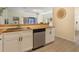 Kitchen with white cabinets, stainless steel dishwasher, and view to the living room at 1065 Universal Rest Pl, Kissimmee, FL 34744