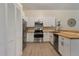 Modern kitchen with stainless steel appliances, white cabinets, and butcher block countertops at 1065 Universal Rest Pl, Kissimmee, FL 34744