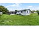 This backyard showcases a spacious lawn and a screened-in patio, perfect for outdoor enjoyment at 10800 Fernando St, Orlando, FL 32825
