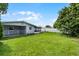 Spacious backyard featuring a well-maintained lawn, partial fence, and screened-in patio at 10800 Fernando St, Orlando, FL 32825