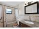 Elegant bathroom with granite vanity, neutral tiled walls, shower-tub combo, and decorative mirror at 10800 Fernando St, Orlando, FL 32825