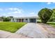 Inviting single story home with a lush green lawn, long driveway and carport at 10800 Fernando St, Orlando, FL 32825
