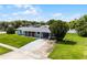 Inviting single story home with a lush green lawn, long driveway and covered parking area at 10800 Fernando St, Orlando, FL 32825