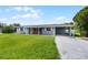 Charming single story home with lush green lawn, brick accents, and convenient carport at 10800 Fernando St, Orlando, FL 32825