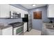 The kitchen features stainless steel appliances, granite counters, and sleek white cabinets at 10800 Fernando St, Orlando, FL 32825