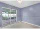 This room features a sliding glass door, paneling, neutral flooring, and a ceiling light at 10800 Fernando St, Orlando, FL 32825
