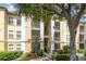 Condo building with tan and white exterior, screened balconies, and mature tree providing shade at 1125 Lake Shadow Cir # 5308, Maitland, FL 32751