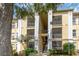 Exterior view of condo building with screened balconies, landscaping, and a large tree at 1125 Lake Shadow Cir # 5308, Maitland, FL 32751
