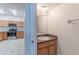 Cozy bathroom with a single sink vanity, a mirror, and a view of the kitchen at 1129 Royal Ridge Dr, Davenport, FL 33896