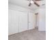 Bedroom with large closet doors, ceiling fan and neutral carpet at 1129 Royal Ridge Dr, Davenport, FL 33896