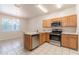 Modern kitchen with stainless steel appliances, tile floors, and wooden cabinets overlooking the dining area at 1129 Royal Ridge Dr, Davenport, FL 33896