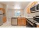 Well-equipped kitchen with stainless steel appliances and wooden cabinets, open to the adjacent living spaces at 1129 Royal Ridge Dr, Davenport, FL 33896