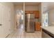 Kitchen featuring stainless steel refrigerator, wooden cabinets, and tile flooring with an open layout at 1129 Royal Ridge Dr, Davenport, FL 33896