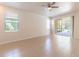 Bright, spacious main bedroom featuring tile flooring, two windows, and access to a screened lanai at 1129 Royal Ridge Dr, Davenport, FL 33896