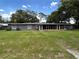 A view of the backyard with manicured lawn, mature trees, and screened porch at 1130 W Lake Brantley Rd, Altamonte Springs, FL 32714