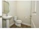 A clean and simple half-bathroom with a pedestal sink, toilet, and white trim at 1222 Castlevecchio Loop, Orlando, FL 32825