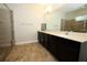 Bathroom with a double sink vanity, stone counters, tile floor, and separate shower at 1222 Castlevecchio Loop, Orlando, FL 32825