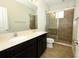 Bright bathroom featuring a double vanity, large mirror, and glass shower at 1222 Castlevecchio Loop, Orlando, FL 32825