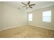A bright and spacious bedroom with two windows and a ceiling fan at 1222 Castlevecchio Loop, Orlando, FL 32825