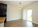 Bright dining area with modern lighting, wood flooring, adjacent to the kitchen, and sliding glass door at 1222 Castlevecchio Loop, Orlando, FL 32825