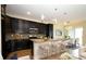 Modern kitchen with dark cabinets, granite countertops, a breakfast bar, and stainless steel appliances at 1222 Castlevecchio Loop, Orlando, FL 32825