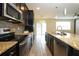 A modern kitchen showcasing dark cabinets, granite counters, stainless steel appliances, and wood-look tile at 1222 Castlevecchio Loop, Orlando, FL 32825