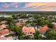 Stunning aerial view of estate home with private pool, tile roof, lush landscaping and a beautiful sunset at 1274 Prince Ct, Lake Mary, FL 32746