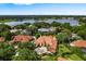 Beautiful aerial view of a tile roof estate home surrounded by trees and a serene lake view at 1274 Prince Ct, Lake Mary, FL 32746