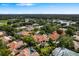Picturesque aerial view of tile roof homes near a lake and golf course in a lush, green community at 1274 Prince Ct, Lake Mary, FL 32746