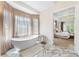Spa-like bathroom with a freestanding tub, marble floors and a view into the main bedroom at 1274 Prince Ct, Lake Mary, FL 32746