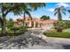 Charming home with terracotta roof, palm trees, manicured lawn, and circular driveway at 1274 Prince Ct, Lake Mary, FL 32746