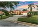 Landscaped front yard showcasing a home with a tile roof, circular driveway, and lush green bushes at 1274 Prince Ct, Lake Mary, FL 32746