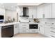 Close-up of a modern kitchen with white cabinets, marble counters, and black appliances at 1274 Prince Ct, Lake Mary, FL 32746