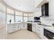 Bright, open kitchen with white cabinets, island sink, stainless steel appliances and a view to the living area at 1274 Prince Ct, Lake Mary, FL 32746
