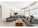 Bright living room with a large sectional sofa, modern chandelier, and seamless flow to the kitchen at 1274 Prince Ct, Lake Mary, FL 32746