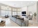 Open-concept living room with large windows, a gray sectional sofa, and a fireplace at 1274 Prince Ct, Lake Mary, FL 32746