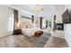 Elegant main bedroom with tray ceilings, wood floors, and a cozy seating area near the French doors at 1274 Prince Ct, Lake Mary, FL 32746