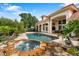 Stunning pool with rock waterfall and spa, complemented by the home's architecture and landscaping at 1274 Prince Ct, Lake Mary, FL 32746
