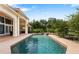 Backyard view of the sparkling pool surrounded by lush greenery and a serene waterfall feature at 1274 Prince Ct, Lake Mary, FL 32746