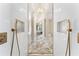 Modern glass shower with marble tile, gold accents, and a view into the bathroom at 1274 Prince Ct, Lake Mary, FL 32746
